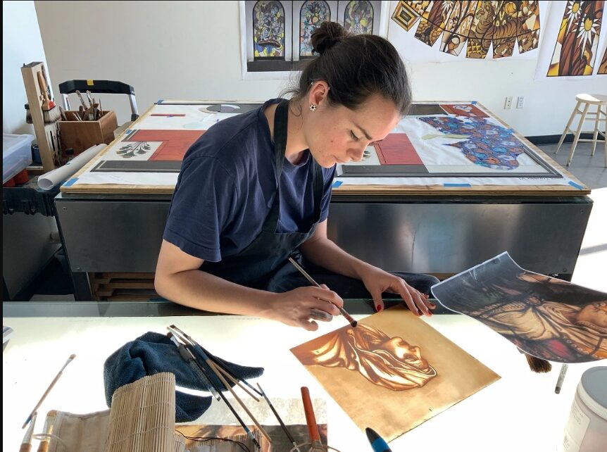 Lola Pradeilles painting on a light table in her studio