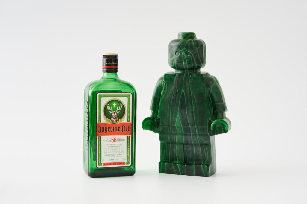 a green glass figurine and a bottle of liquor