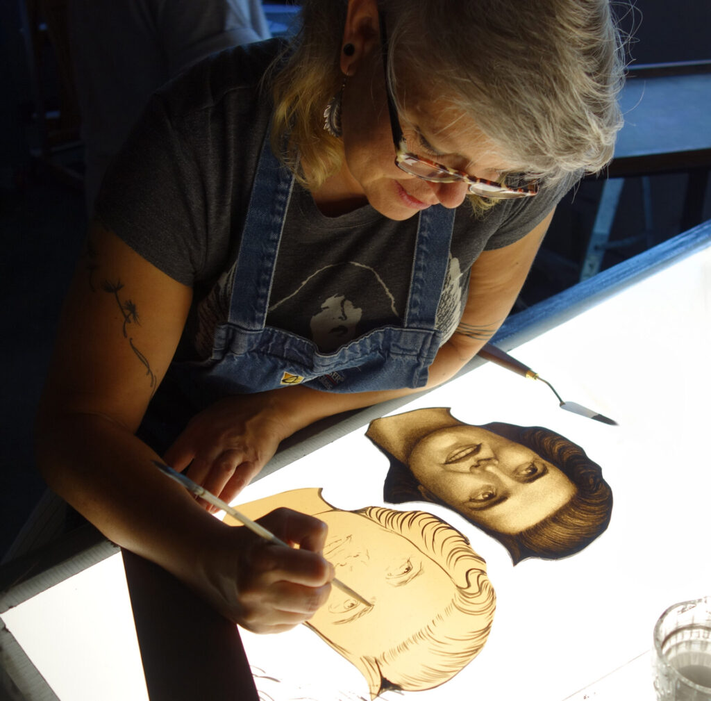a person painting a stained glass image